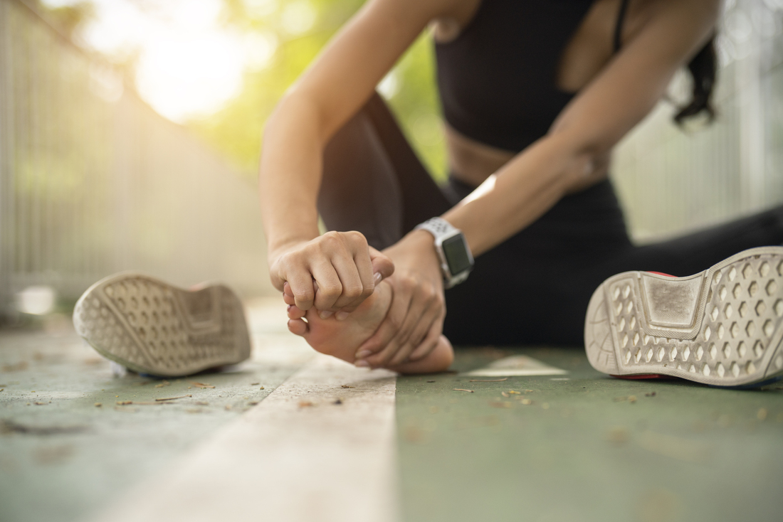 Woman sitting and holding front of foot in hands.jpg