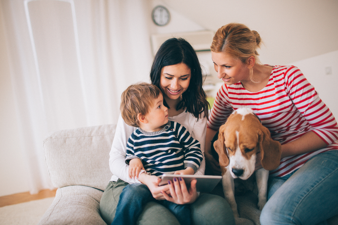 Family with two woman, a child and their dog sitting on couch.jpg