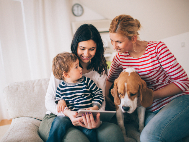 Family with two woman, a child and their dog sitting on couch.jpg