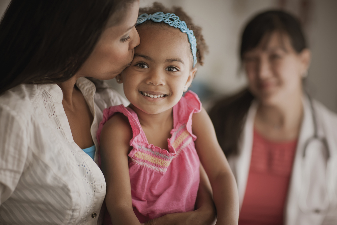 Mother kissing childs head in doctors office.jpg
