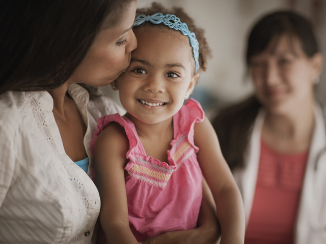 Mother kissing childs head in doctors office.jpg