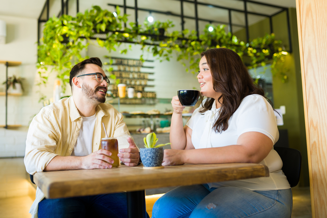 Two people drinking and talking in cafe
