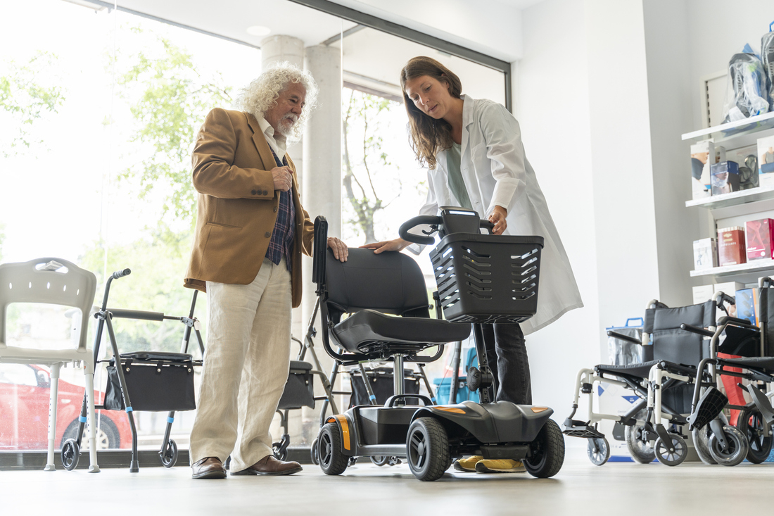 Staff showing electric scooter to senior man.jpg