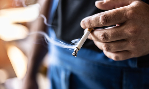 Man holding cigarette smoking.jpg