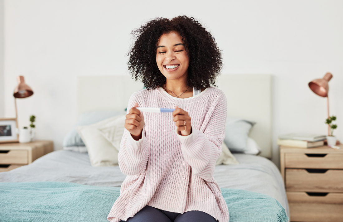 Happy woman with pregnancy test.jpg