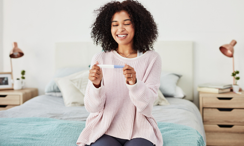 Happy woman with pregnancy test.jpg