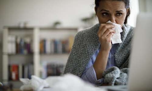Sick woman blowing nose.jpg