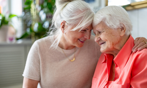 Smiling senior woman sitting with daughter