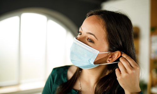 Woman putting on medical face mask.jpg