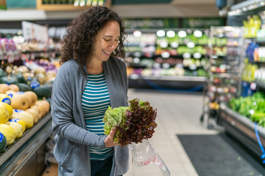 Woman holding lettuce in grocery store
