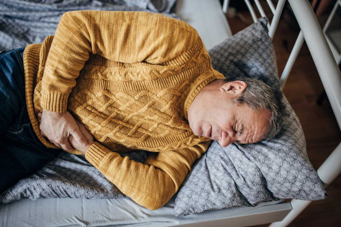 Man on couch with stomach pain.jpg