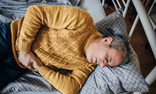 Man on couch with stomach pain.jpg