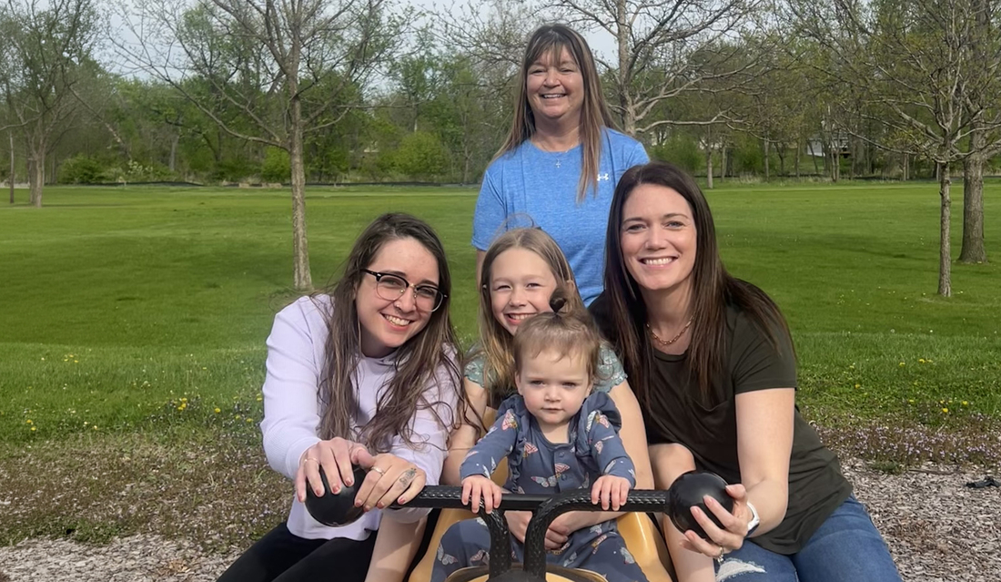 Tracey smiling at camera posing with two daughters and two granddaughers.jpg