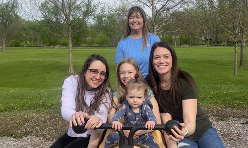 Tracey smiling at camera posing with two daughters and two granddaughers.jpg
