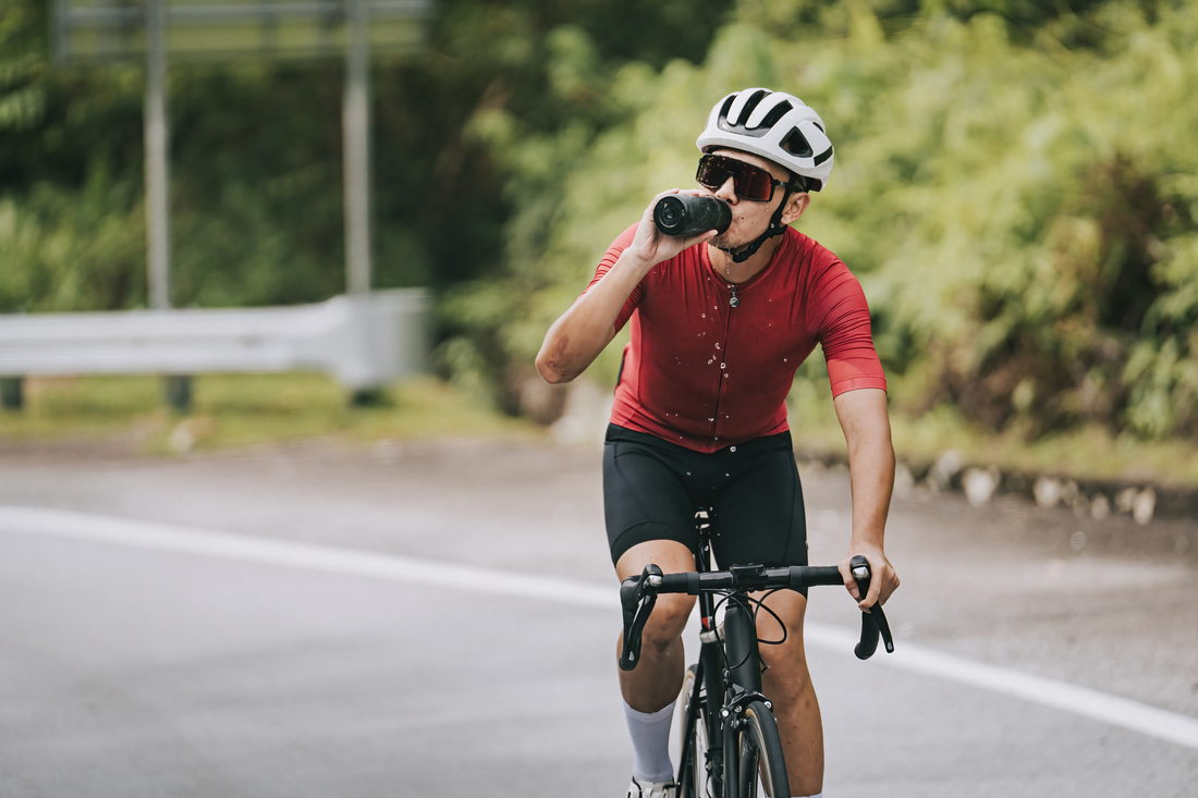 Man on bike drinking from water bottle.jpg