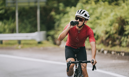 Man on bike drinking from water bottle.jpg