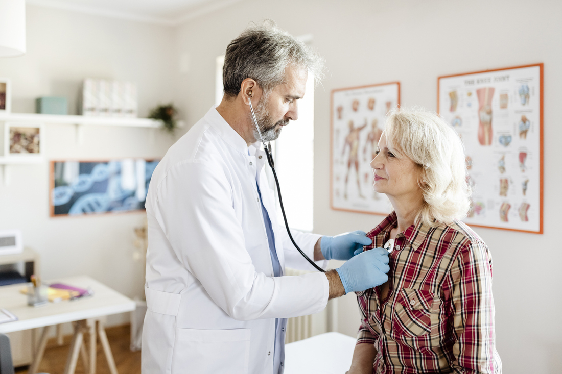 Doctor checking womans heart with stethoscope.jpg