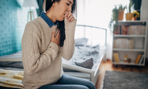 Woman coughing holding chest.jpg
