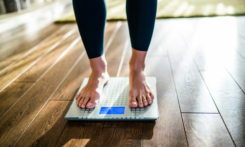 Womans feet stepping on scale.jpg