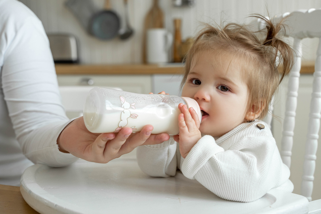 Baby girl drinking milk from bottle.jpg