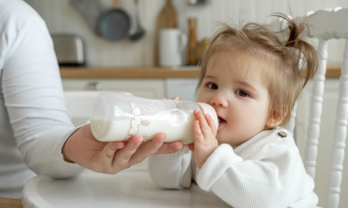 Baby girl drinking milk from bottle.jpg