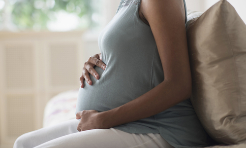 Pregnant woman holding belly third trimester.jpg