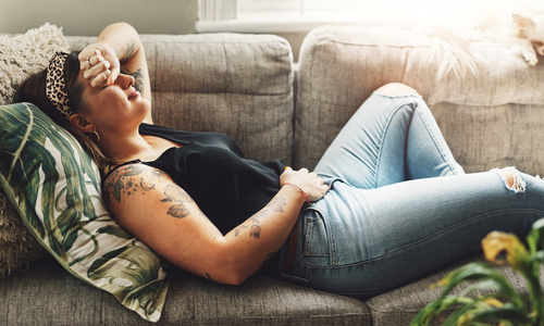 Woman with period cramps lying on couch.jpg