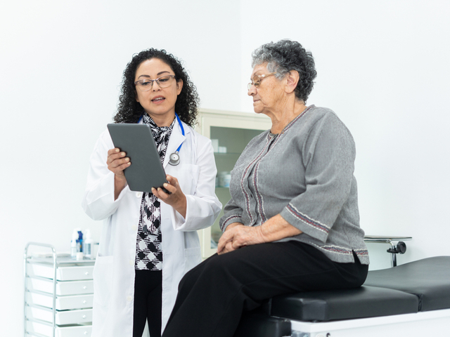 Doctor talking to patient using tablet