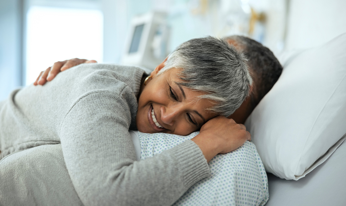 Happy woman hugging man in hospital bed.jpg