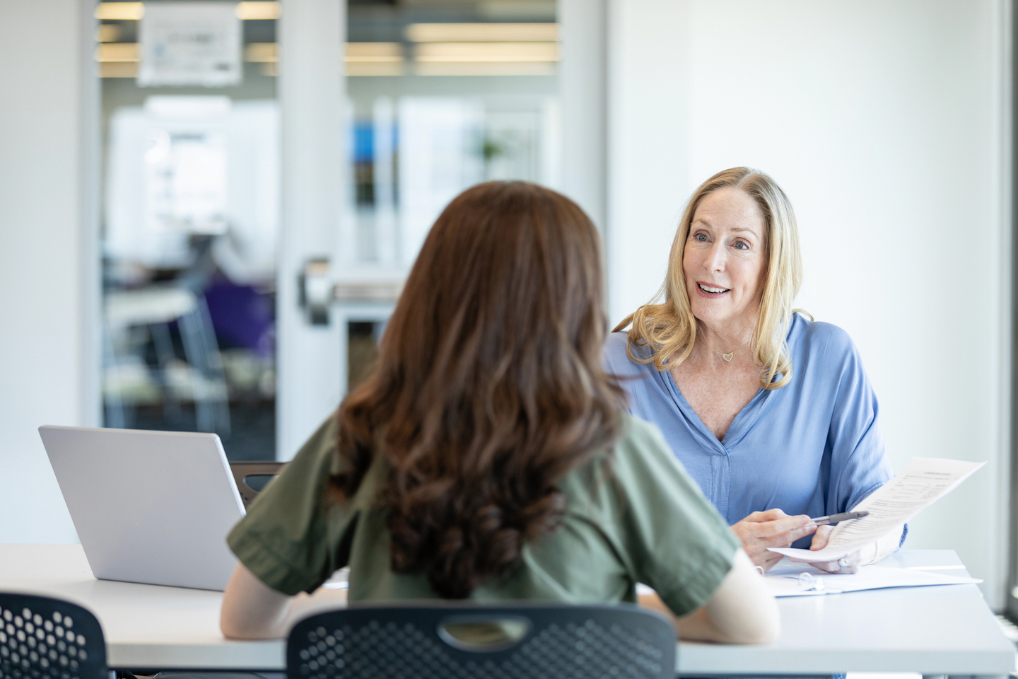 Female financial counselor talking to two patients.jpg
