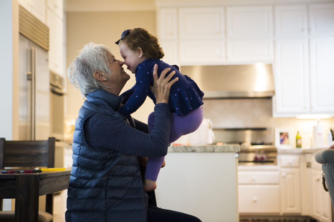 Grandmother holding up granchild smiling