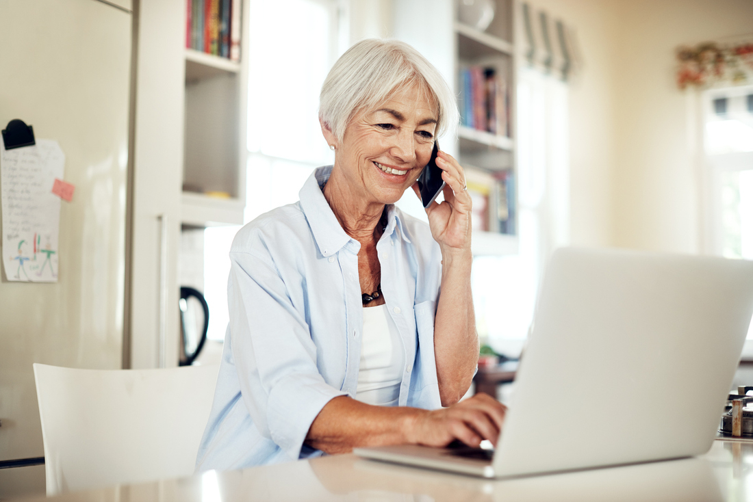 Woman speaking on phone with open laptop.jpg