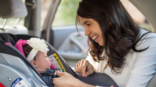 Woman buckling baby into car seat.jpg