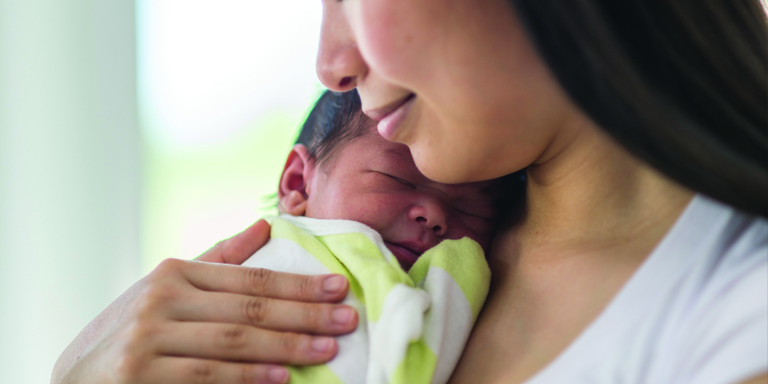Mother holding newborn to chest