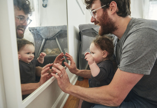 6 month old looking at self in mirror.jpg