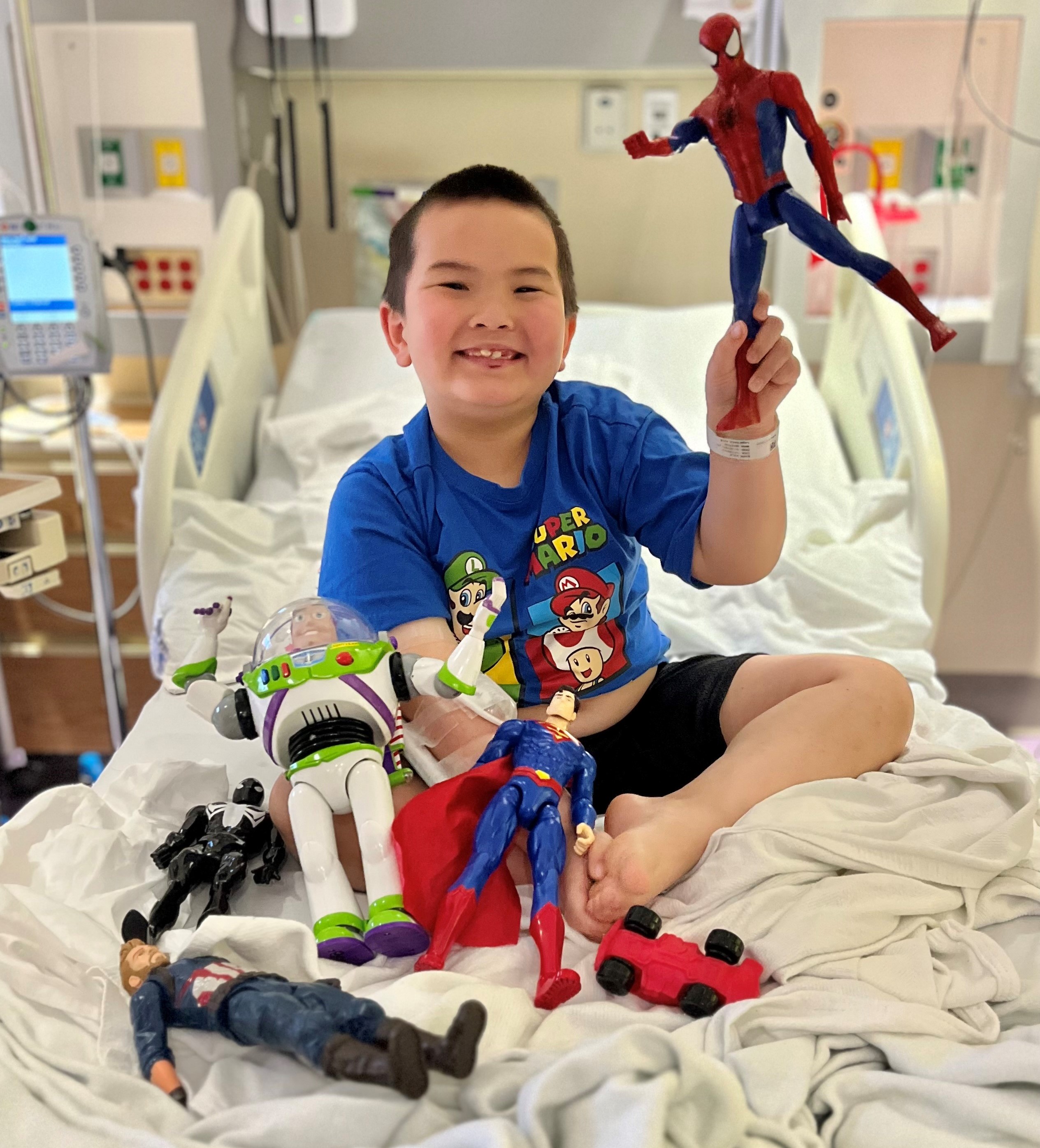 Child holding toys in hospital bed.jpg