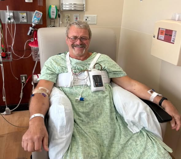 Tom Roschen smiling in hospital gown