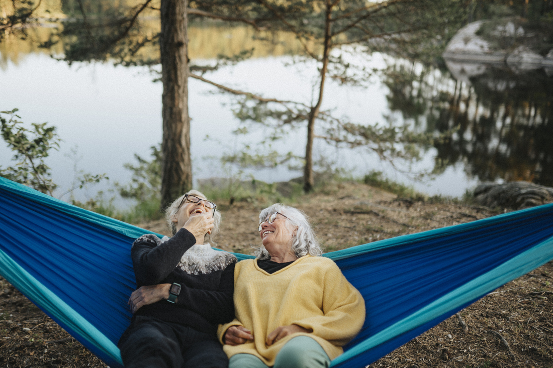 Two happy senior women hammocking outside.jpg