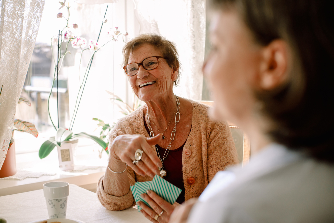 Senior woman smiling playing cards.jpg
