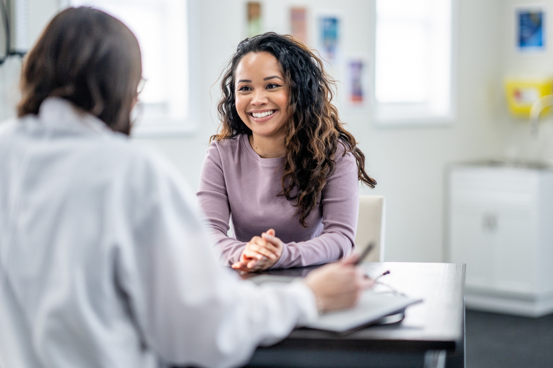 Smiling female patient talking to doctor.jpg