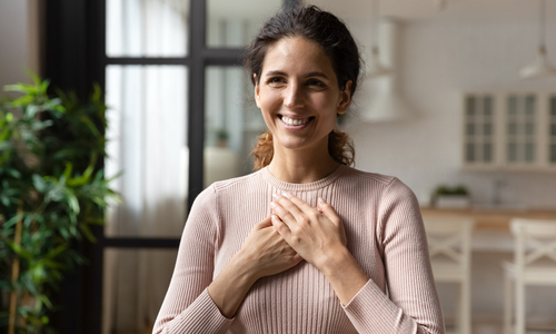 Happy woman holding hands over heart.jpg