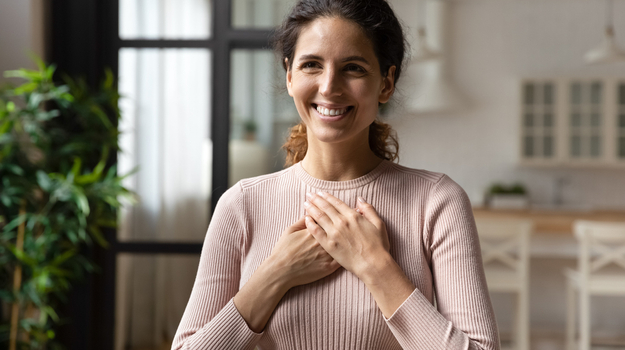 Happy woman holding hands over heart.jpg