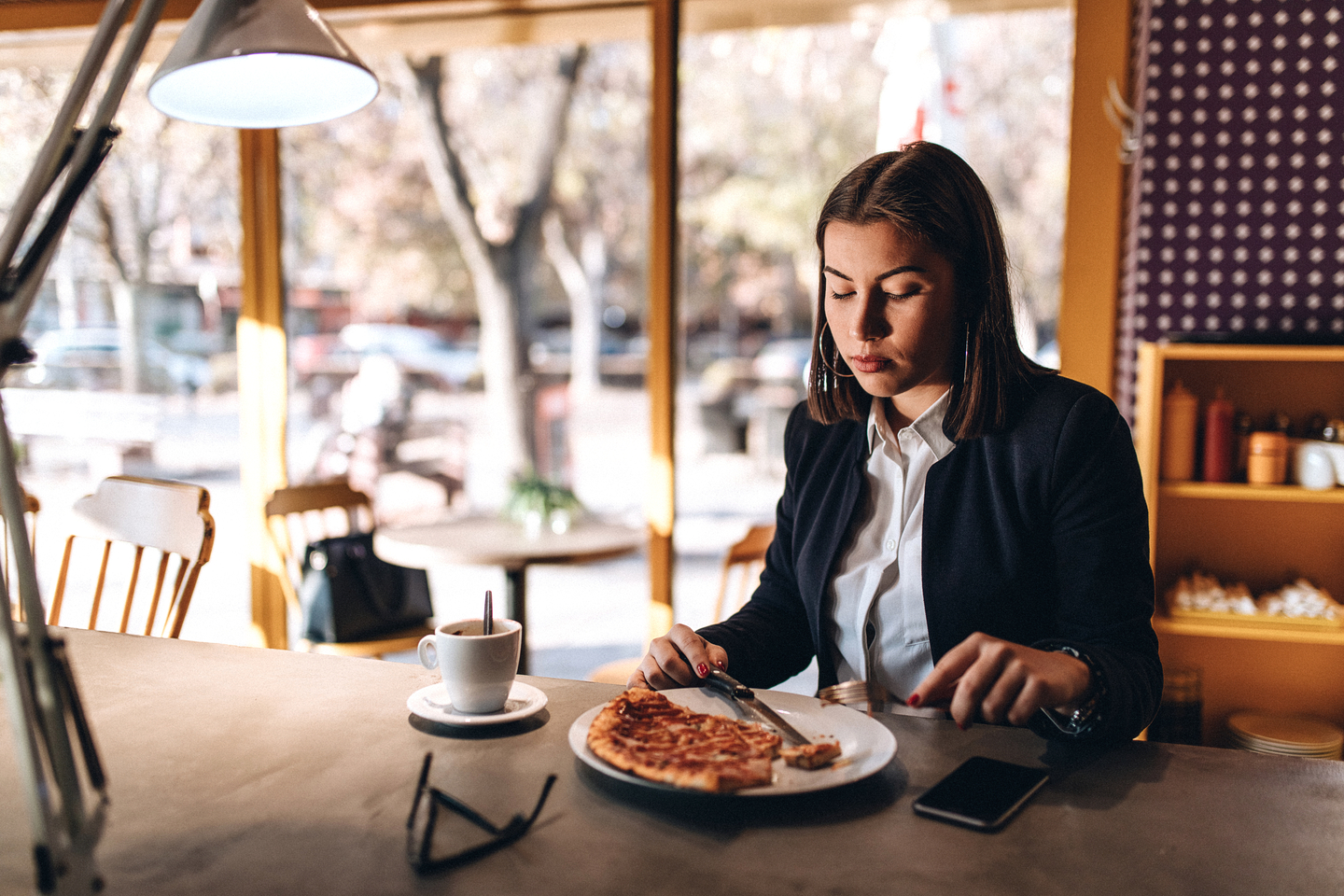 Woman sitting at table looking down at food 