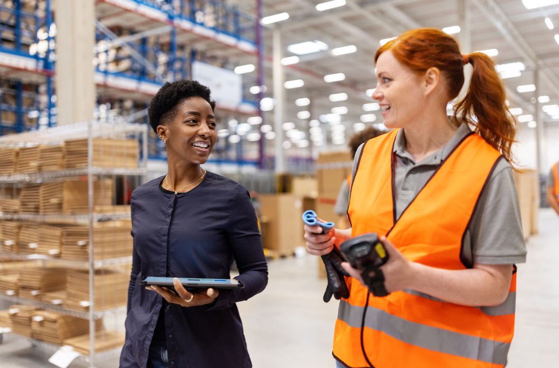 Two woman talking and walking at Industrial job site