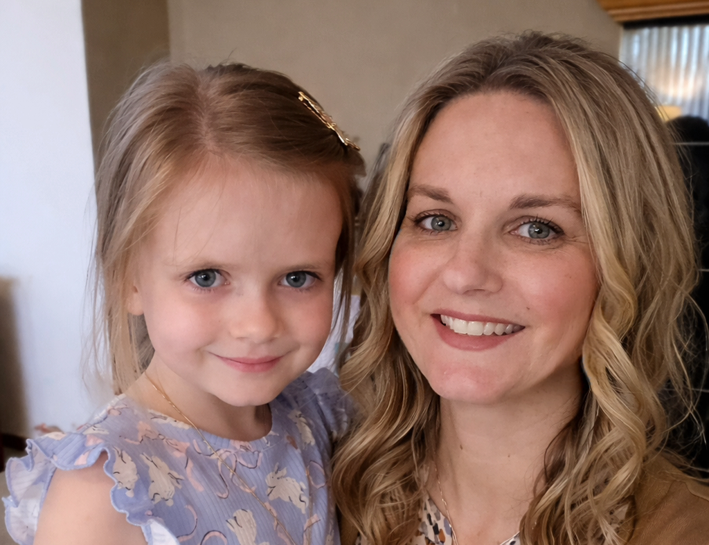 Jill Ironside and standing and smiling with five-year-old daughter Iris.png