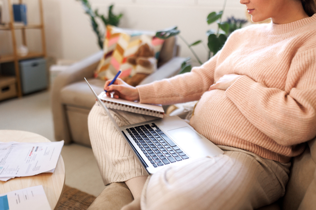Pregnant woman with laptop and notepad.jpg