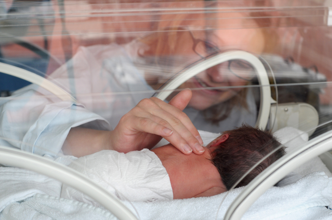 Mother touching NICU baby.png