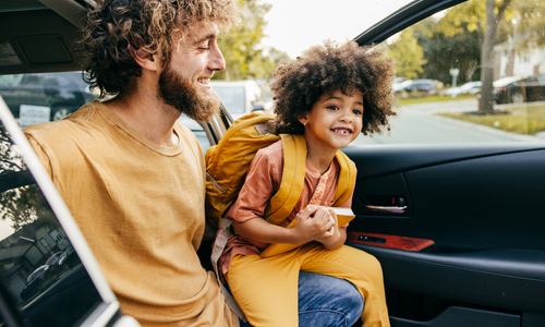Happy dad helping child out of car.jpg