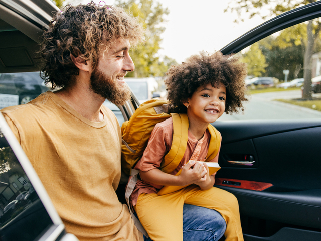Happy dad helping child out of car.jpg