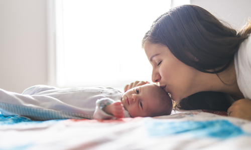 Mother kissing head of premature baby.jpg